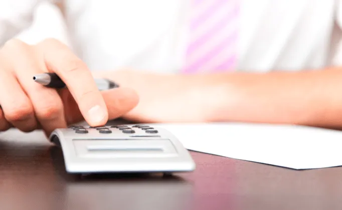 Un conseiller utilisant une calculatrice pour établir le devis détaillé de prestations funèbres