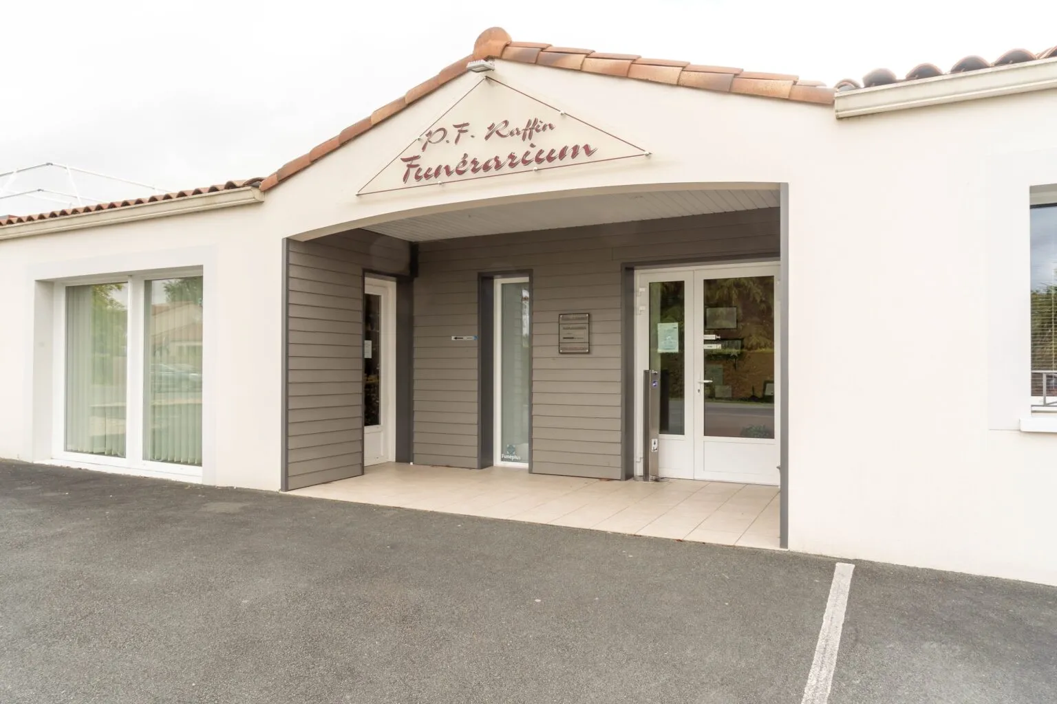 Entrée principale du funérarium P.F. Raffin avec portes vitrées et auvent