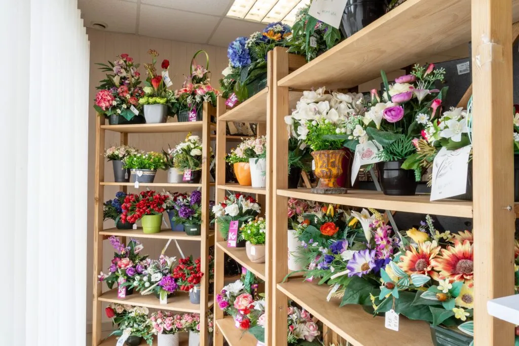 Étagères en bois présentatrices de compositions florales artificielles de funérarium
