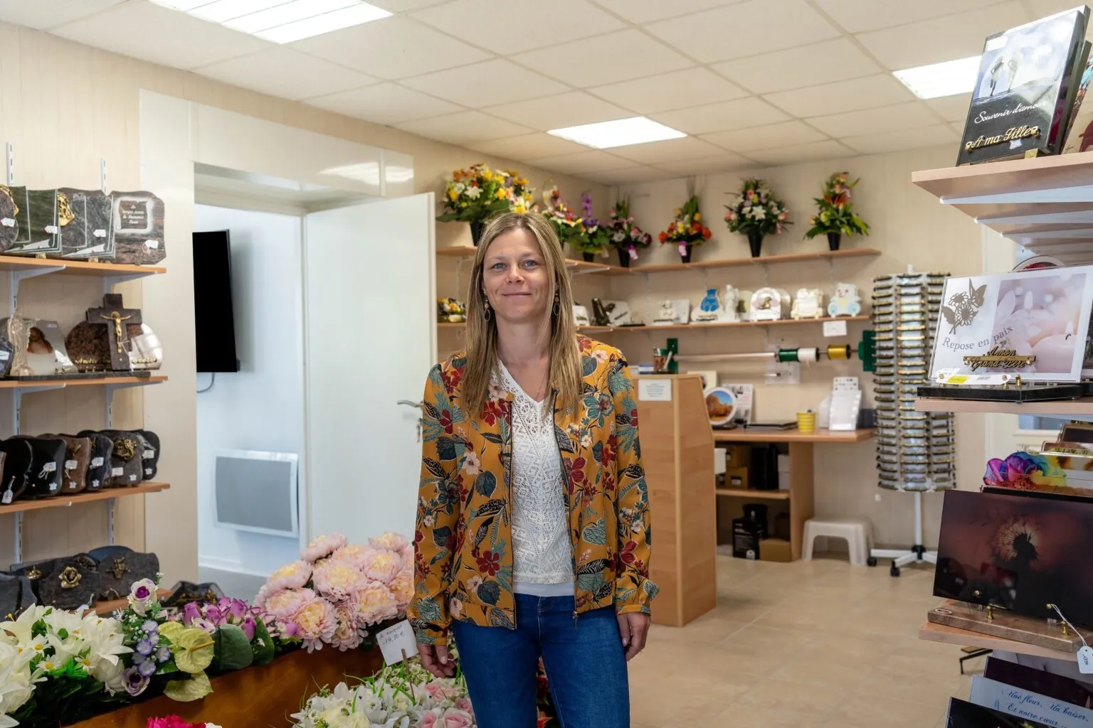 Conseillère funéraire souriante au milieu du magasin d'articles d'hommage
